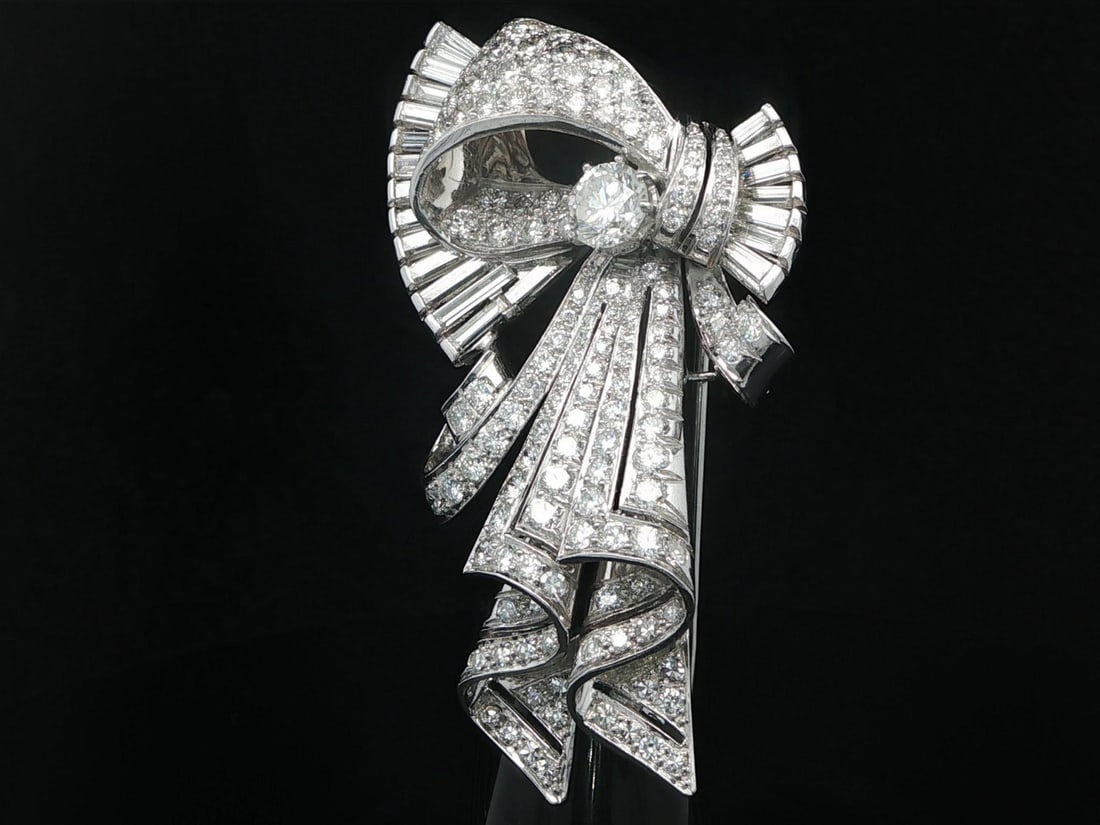 Mid Century Diamond Ribbon Brooch in Platinum and White Gold 7.47ctw: Mid Century Diamond Ribbon Brooch in Platinum and White Gold 7.47ctw This striking mid-century statement brooch features a ribbon design crafted from solid .850+ platinum and 12-14k white gold. It is