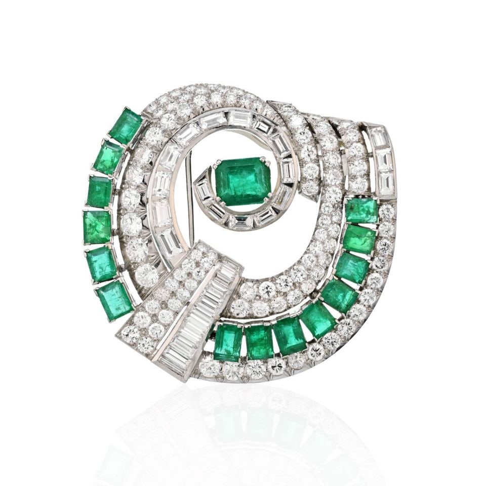 Stunning Art Deco 25 Carat Emerald Diamond Platinum Brooch: Stunning Art Deco 25 Carat Emerald Diamond Platinum Brooch This exquisite Art Deco brooch showcases a stunning geometric design, featuring a magnificent 15 carat green emerald at its center, beautiful