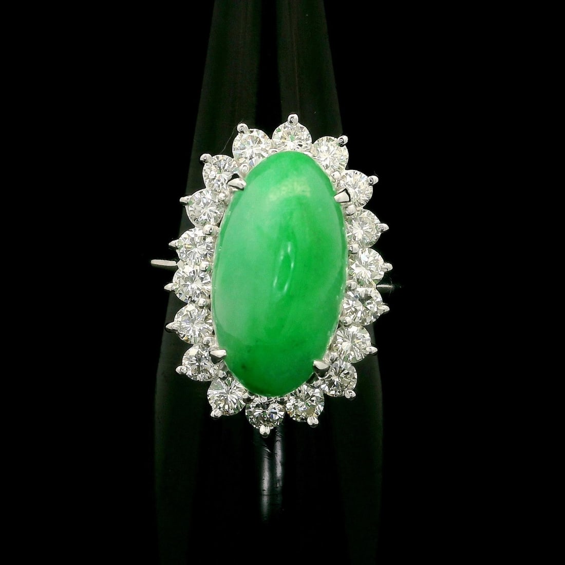 Platinum GIA Certified 7.47ctw Burma Jade Diamond Halo Cocktail Ring: Platinum GIA Certified 7.47ctw Burma Jade Diamond Halo Cocktail Ring This exquisite cocktail ring showcases a stunning natural jade stone, specifically an elongated oval cabochon cut, with a vibrant g