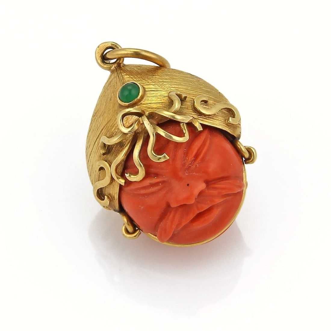 Double Sided Warrior Face Pendant in 18k Gold with Carved Coral and Emerald Accents: Double Sided Warrior Face Pendant in 18k Gold with Carved Coral and Emerald Accents This vintage pendant features a finely hand-carved double-sided warrior face crafted from natural dark red coral. Se