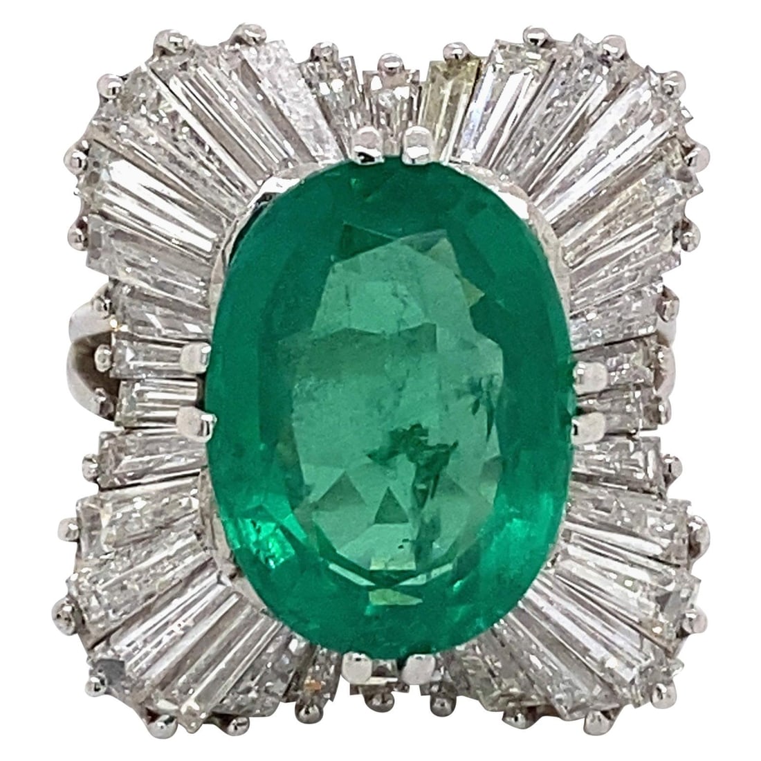 6.72 Carat Oval Emerald Art Deco Ring with Baguette Diamond Halo in 18K White Gold: 6.72 Carat Oval Emerald Art Deco Ring with Baguette Diamond Halo in 18K White Gold This exquisite Art Deco-inspired ring features a stunning 6.72-carat oval emerald, complemented by a dazzling halo of