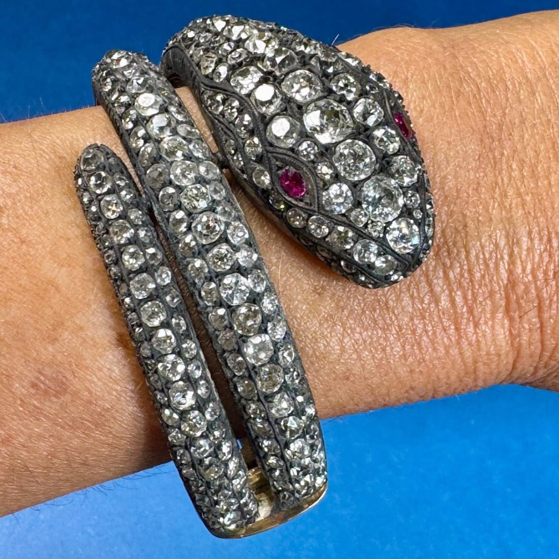 18K Silver 58.25 Ct Diamond Ruby Snake Bangle: 18K Silver 58.25 Ct Diamond Ruby Snake Bangle This stunning bangle features a unique snake design crafted from 18K gold and silver, weighing 98.7 grams. It is adorned with approximately 58.25 carats o