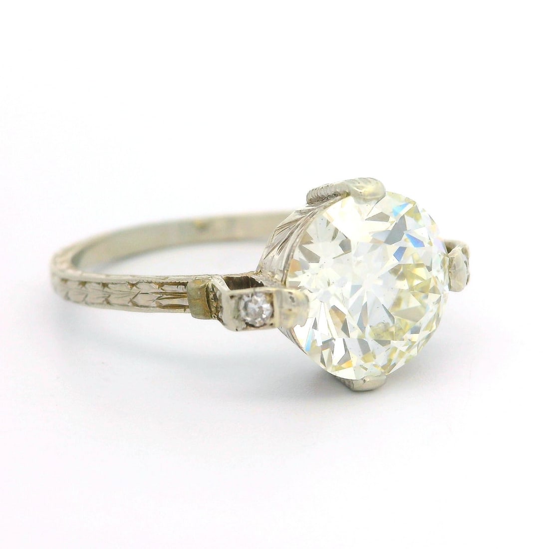 Antique Art Deco 18k White Gold GIA 2.37ct Diamond Hand Engraved Ring: Antique Art Deco 18k White Gold GIA 2.37ct Diamond Hand Engraved Ring This exquisite Antique Art Deco ring showcases a stunning 2.37ct Old European Cut diamond, certified by GIA. The main stone exhibi