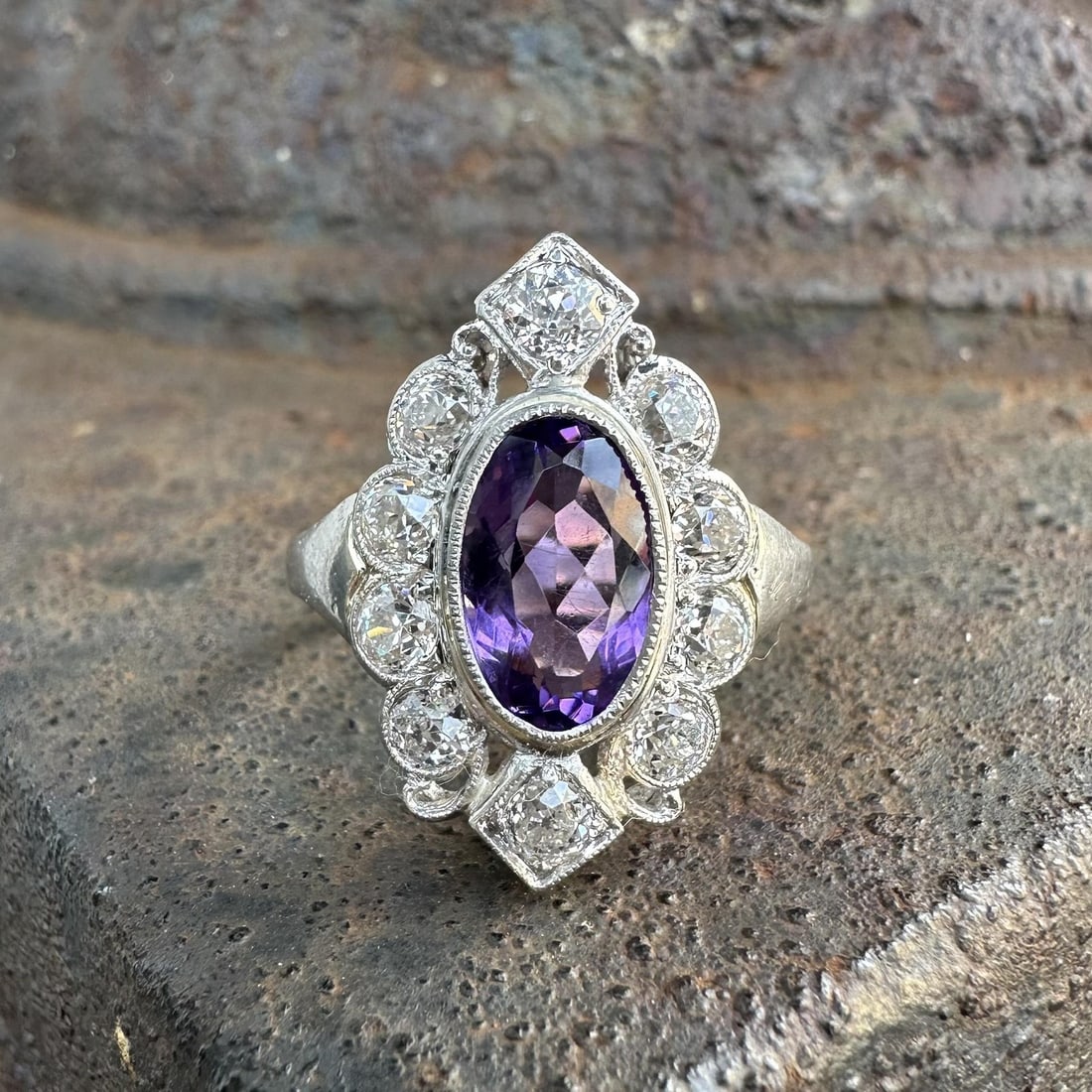 Platinum Art Deco Cocktail Ring with Amethyst and Old Mine Cut Diamonds: Platinum Art Deco Cocktail Ring with Amethyst and Old Mine Cut Diamonds This Art Deco platinum cocktail ring features a natural oval-cut amethyst weighing approximately 1.80 carats, accented by ten ol