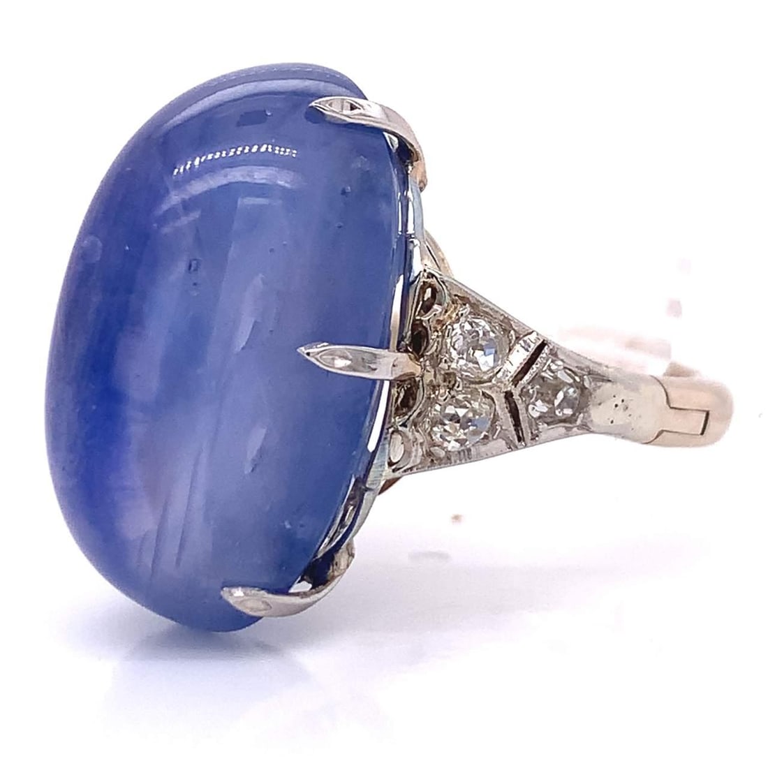 Antique 48.39 Ct Star Sapphire Diamond Ring H-J VS1-SI2: Antique 48.39 Ct Star Sapphire Diamond Ring H-J VS1-SI2 This exquisite antique ring showcases a stunning oval cabochon star sapphire weighing 48.39 ct, complemented by 0.70 ct of diamonds. The diamond