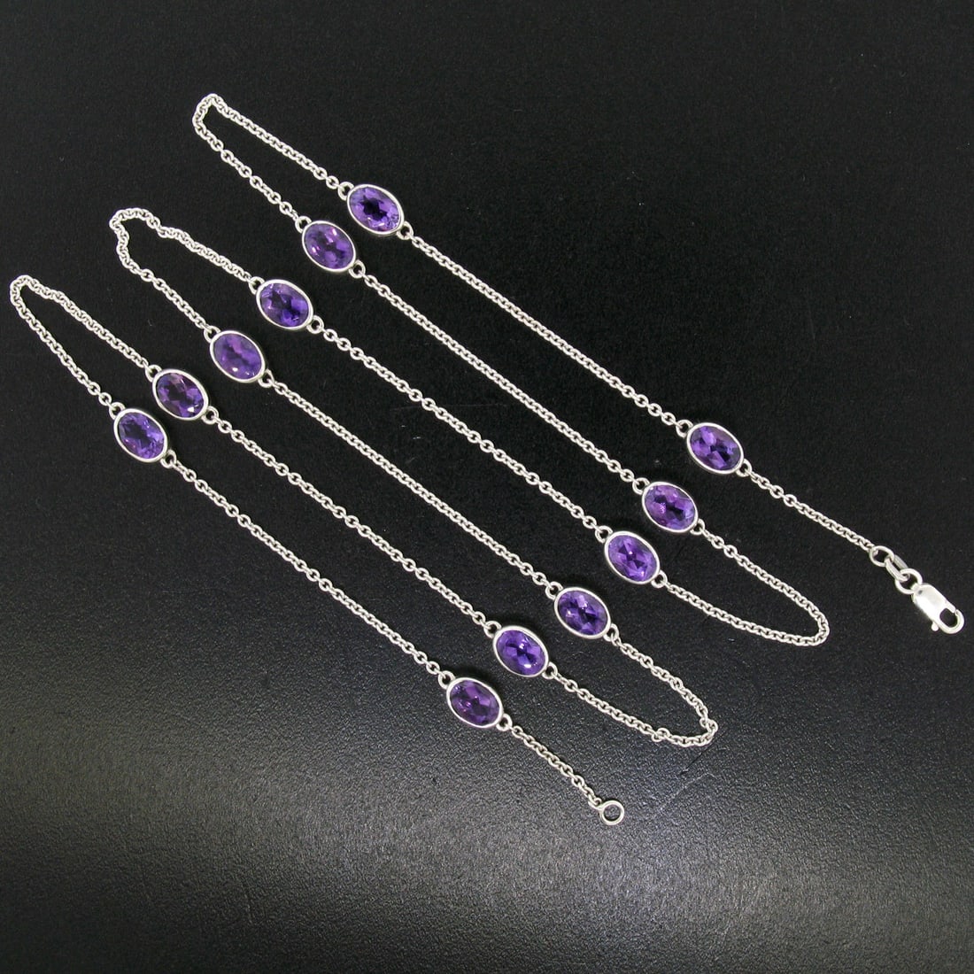 14k White Gold 12 Station 12.96ct Oval Amethyst Necklace 26 Inch: 14k White Gold 12 Station 12.96ct Oval Amethyst Necklace 26 Inch This exquisite necklace showcases a stunning design in solid 14k white gold, featuring 12 beautifully bezel set oval cut amethysts. Eac