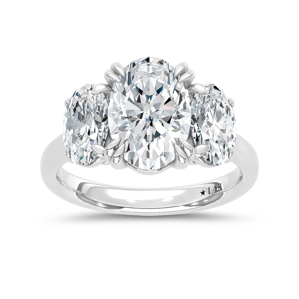 14K White Gold Lab Grown Diamond 5 Ct.Tw. Oval Shape Three Stone Engagement Ring: 14K White Gold Lab Grown Diamond 5 Ct.Tw. Oval Shape Three Stone Engagement Ring This stunning three-stone ring features a sparkling 3 CT Oval Center diamond with two shimmering side diamonds, symboli