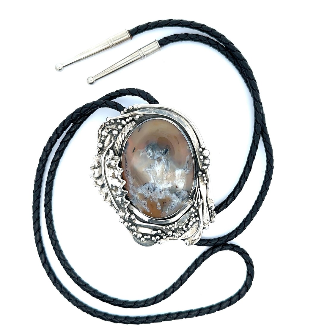 Sterling Silver Bolo Tie Featuring Large Tan Agate by Stan Davidson: Sterling Silver Bolo Tie Featuring Large Tan Agate by Stan Davidson This vintage bolo tie features a large, natural oval agate cabochon with a translucent tan base and grey and white plumes, bezel set