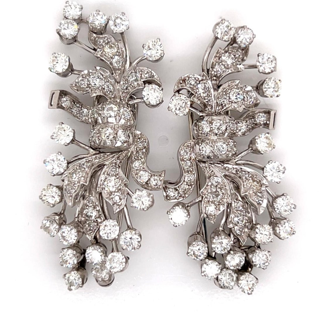 Art Deco Platinum Brooch Pair with 9.20 Carat Diamonds: Art Deco Platinum Brooch Pair with 9.20 Carat Diamonds This pair of Art Deco brooches features a platinum setting adorned with approximately 9.20 carats of diamonds. Each brooch is set with 101 diamon