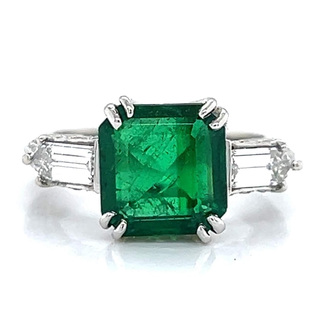 Stunning Platinum Emerald 3.27 Ct and Diamond Ring with 82 Diamonds: Stunning Platinum Emerald 3.27 Ct and Diamond Ring with 82 Diamonds This exquisite Platinum ring features a stunning 3.27 Ct. Emerald at its center, elegantly complemented by two Bullet-cut Diamonds w