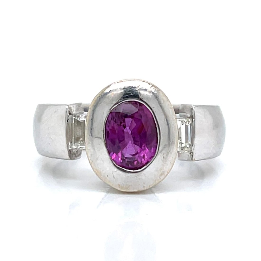 18K White Gold Ring with Pink Sapphire and Diamond Accents: 18K White Gold Ring with Pink Sapphire and Diamond Accents This elegant ring is crafted from 18K white gold and features an approximately 1.10 carat pink sapphire as its centerpiece. It is accented by