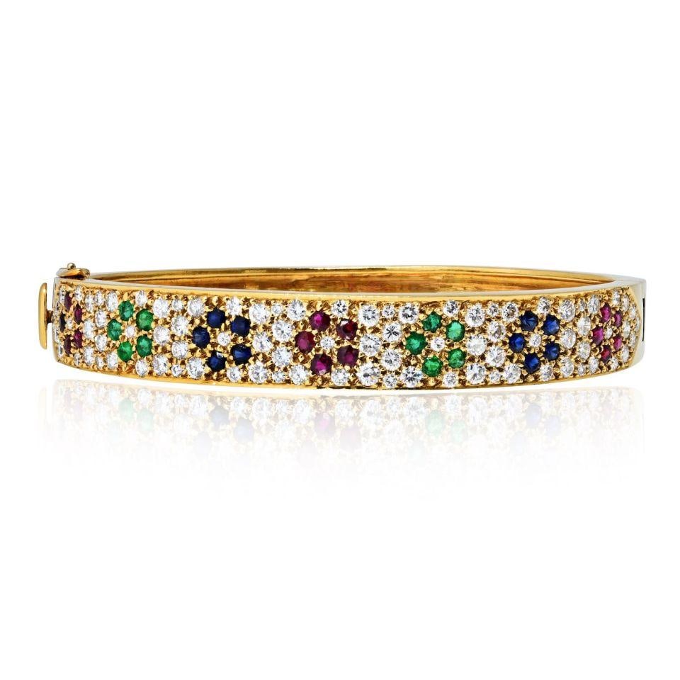 Diamond and Multigem Floral Bangle in 18K Yellow Gold by Van Cleef & Arpels: Diamond and Multigem Floral Bangle in 18K Yellow Gold by Van Cleef & Arpels This Van Cleef & Arpels bangle bracelet is crafted in 18K yellow gold and showcases a floral motif adorned with round diamon