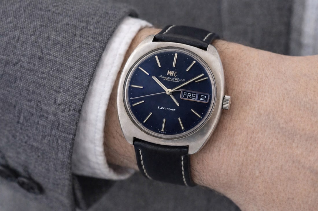 IWC Electronic Caliber 160 Stainless Steel Day Date Vintage 37mm Wristwatch: IWC Electronic Caliber 160 Stainless Steel Day Date Vintage 37mm Wristwatch This vintage IWC Electronic wristwatch features a 37mm brushed stainless steel cushion case with a blue analog dial and bato