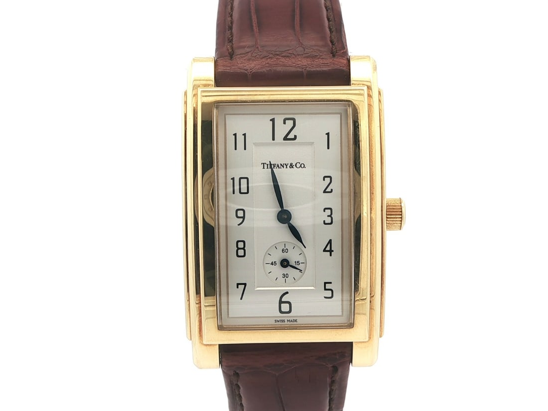 Men's Grand 27mm Rectangular Wristwatch in 18k Yellow Gold by Tiffany & Co.: Men's Grand 27mm Rectangular Wristwatch in 18k Yellow Gold by Tiffany & Co. This Tiffany & Co. Grand men's wristwatch features a solid 18k yellow gold rectangular case measuring 27mm in width and 43.1