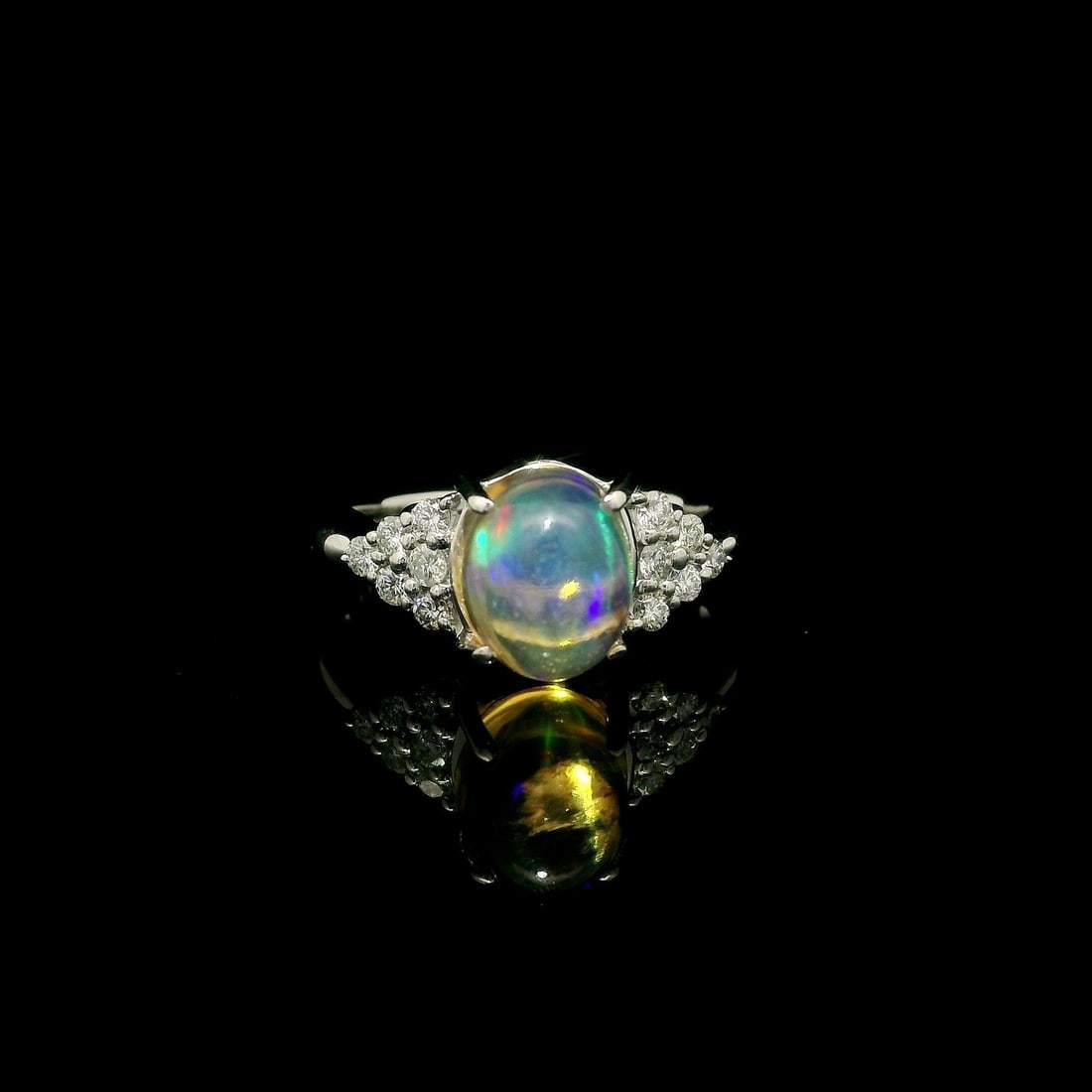 Platinum Cocktail Ring 2.8ct Opal & Diamond Side Stones: Platinum Cocktail Ring 2.8ct Opal & Diamond Side Stones This elegant cocktail ring showcases a stunning natural blue opal in an oval cabochon cut, prong set to highlight its vibrant play of colors. Th