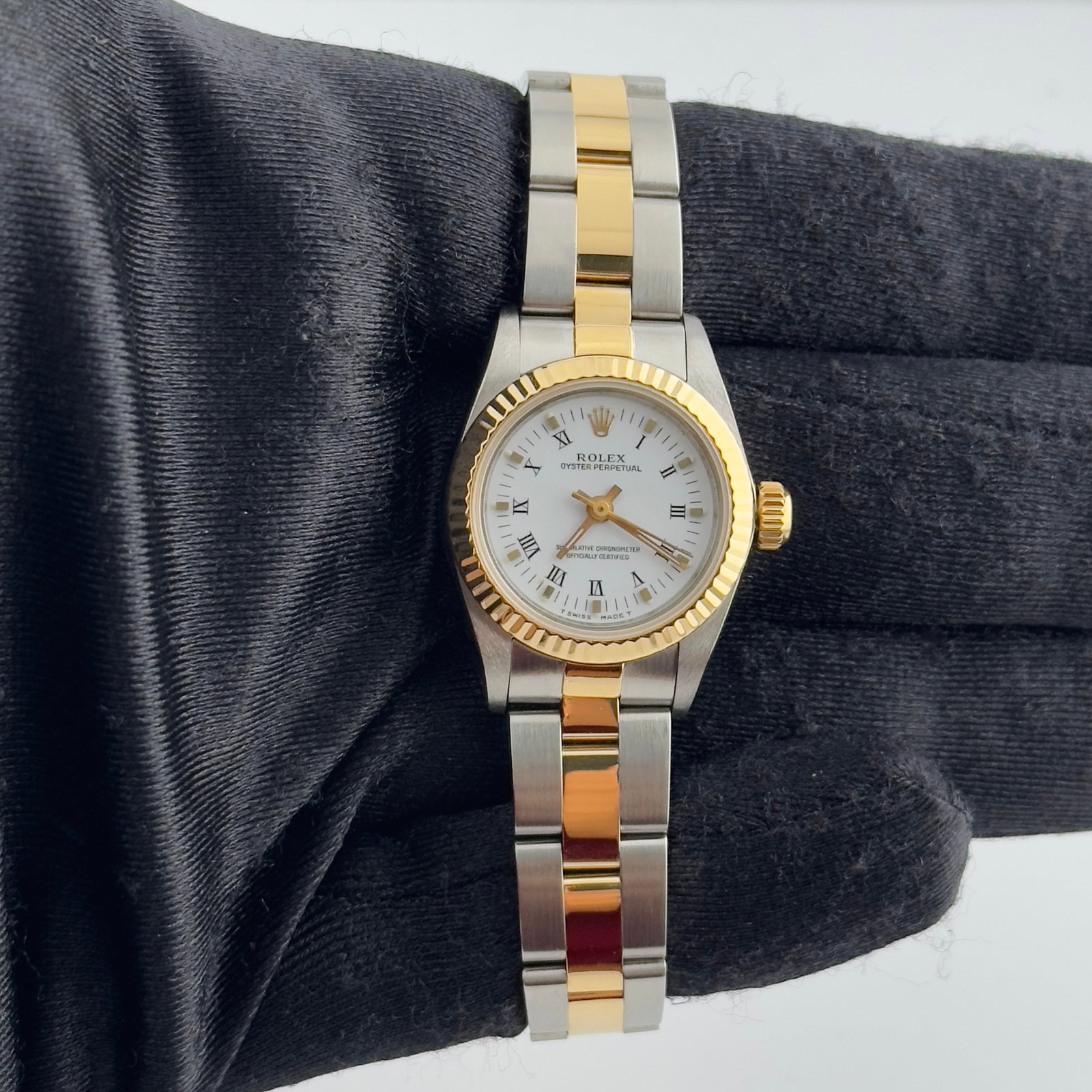 Rolex 67193 Ladies Oyster Perpetual White Roman Dial Watch With Papers 1992: Rolex 67193 Ladies Oyster Perpetual White Roman Dial Watch With Papers 1992 This is a ladies' Rolex Oyster Perpetual watch featuring a white Roman numeral dial and a fluted bezel. The watch is equippe