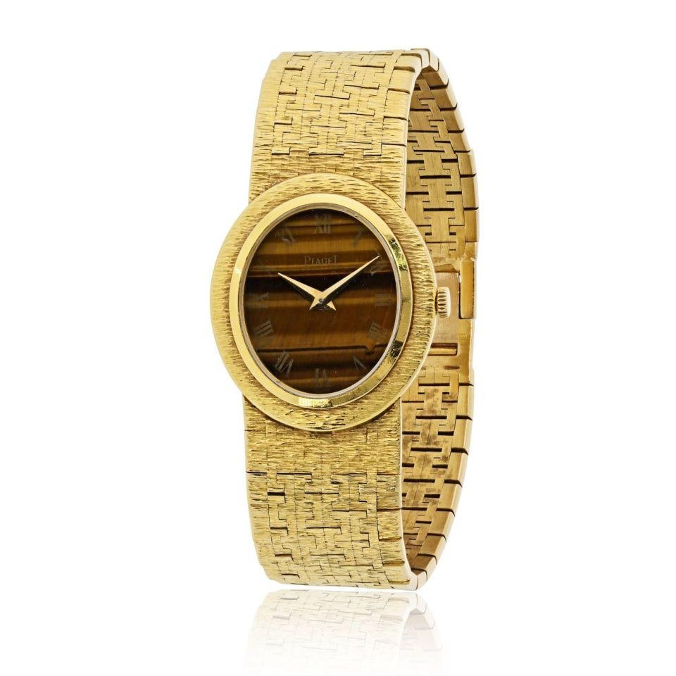 Vintage Oval Tiger Eye Dial Watch in 18K Yellow Gold by Piaget: Vintage Oval Tiger Eye Dial Watch in 18K Yellow Gold by Piaget This Piaget vintage watch features an 18K yellow gold case and an elegant oval tiger's eye dial. It is equipped with an ultra-thin 9P