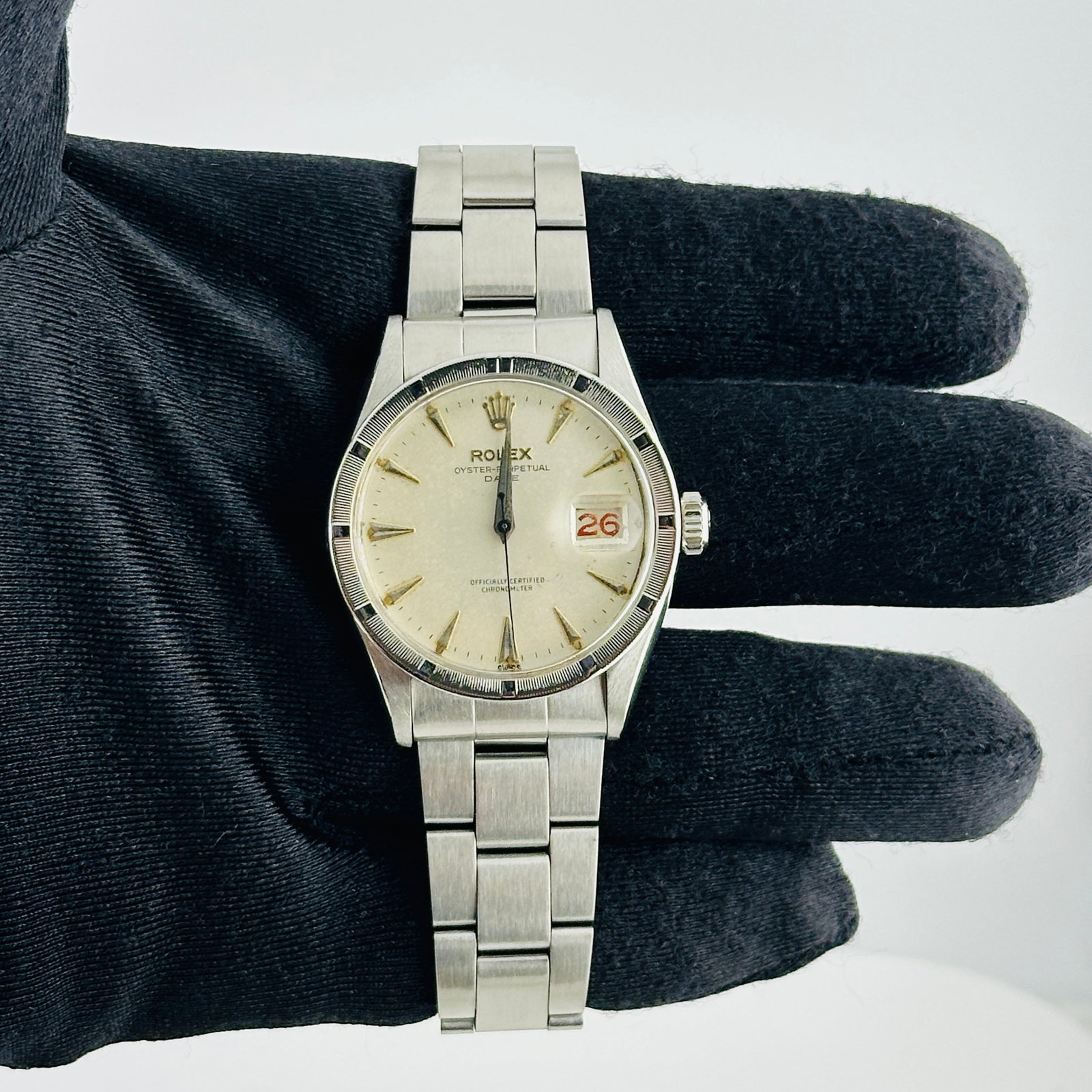 Rolex Oyster Perpetual Date 6535 Silver Stick Dial Oyster Folded Bracelet: Rolex Oyster Perpetual Date 6535 Silver Stick Dial Oyster Folded Bracelet This Rolex Oyster Perpetual Date features a silver stick dial with visible spots, complemented by an engine-turned bezel and a
