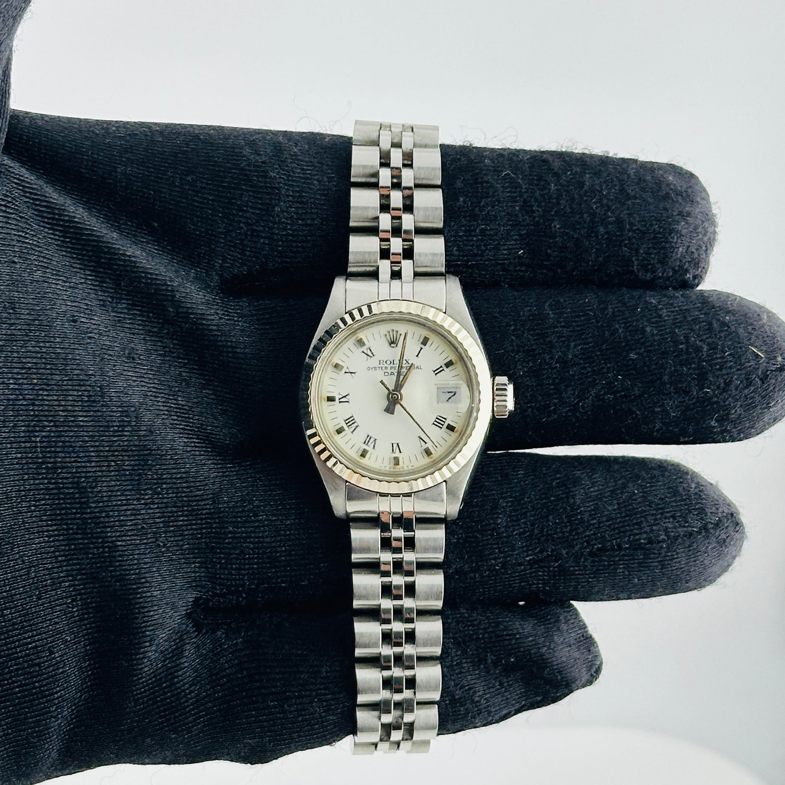 Ladies Rolex Oyster Perpetual Date 6917 White Roman Dial Jubilee Bracelet: Ladies Rolex Oyster Perpetual Date 6917 White Roman Dial Jubilee Bracelet This ladies' Rolex Oyster Perpetual Date features a white Roman numeral dial and a fluted bezel, complemented by a D-Link Jubi