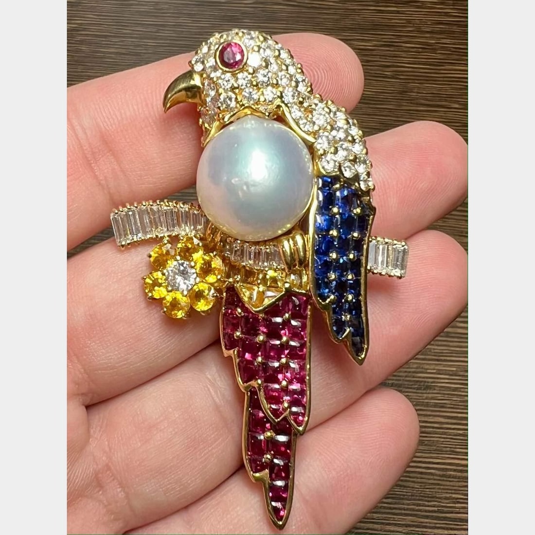 18K Yellow Gold Bird Brooch with Diamonds Rubies Sapphires and Pearl: 18K Yellow Gold Bird Brooch with Diamonds Rubies Sapphires and Pearl This exquisite brooch features a stunning bird design crafted in 18K yellow gold. It is adorned with 82 diamonds totaling 6.80 ct, 