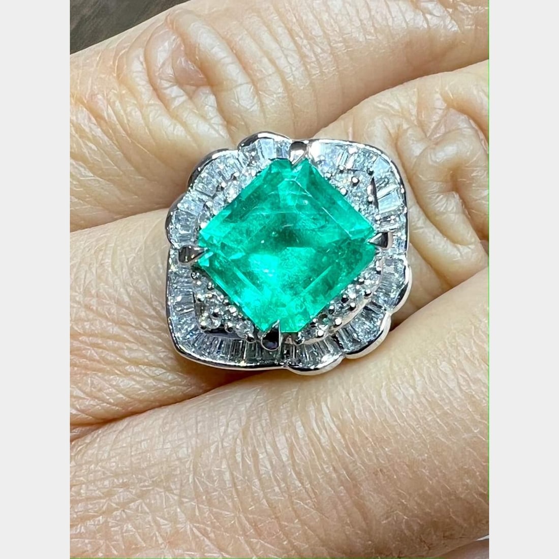 Platinum Emerald 4.17 Ct and 24 Diamond Ring E-G VVS-SI1: Platinum Emerald 4.17 Ct and 24 Diamond Ring E-G VVS-SI1 This stunning platinum ring features a captivating 4.17 Ct. emerald at its center, surrounded by a dazzling array of 24 diamonds totaling 0.84 
