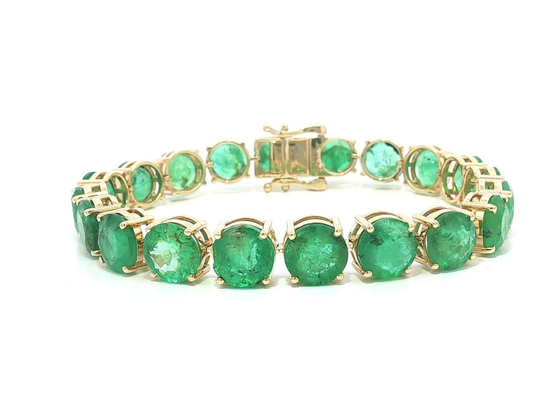 Emerald tennis bracelet 14k yellow gold 24.06ctw 20 stones: Emerald tennis bracelet 14k yellow gold 24.06ctw 20 stones This elegant tennis bracelet features twenty natural round brilliant cut emeralds, totaling approximately 24.06 carats. The emeralds display 