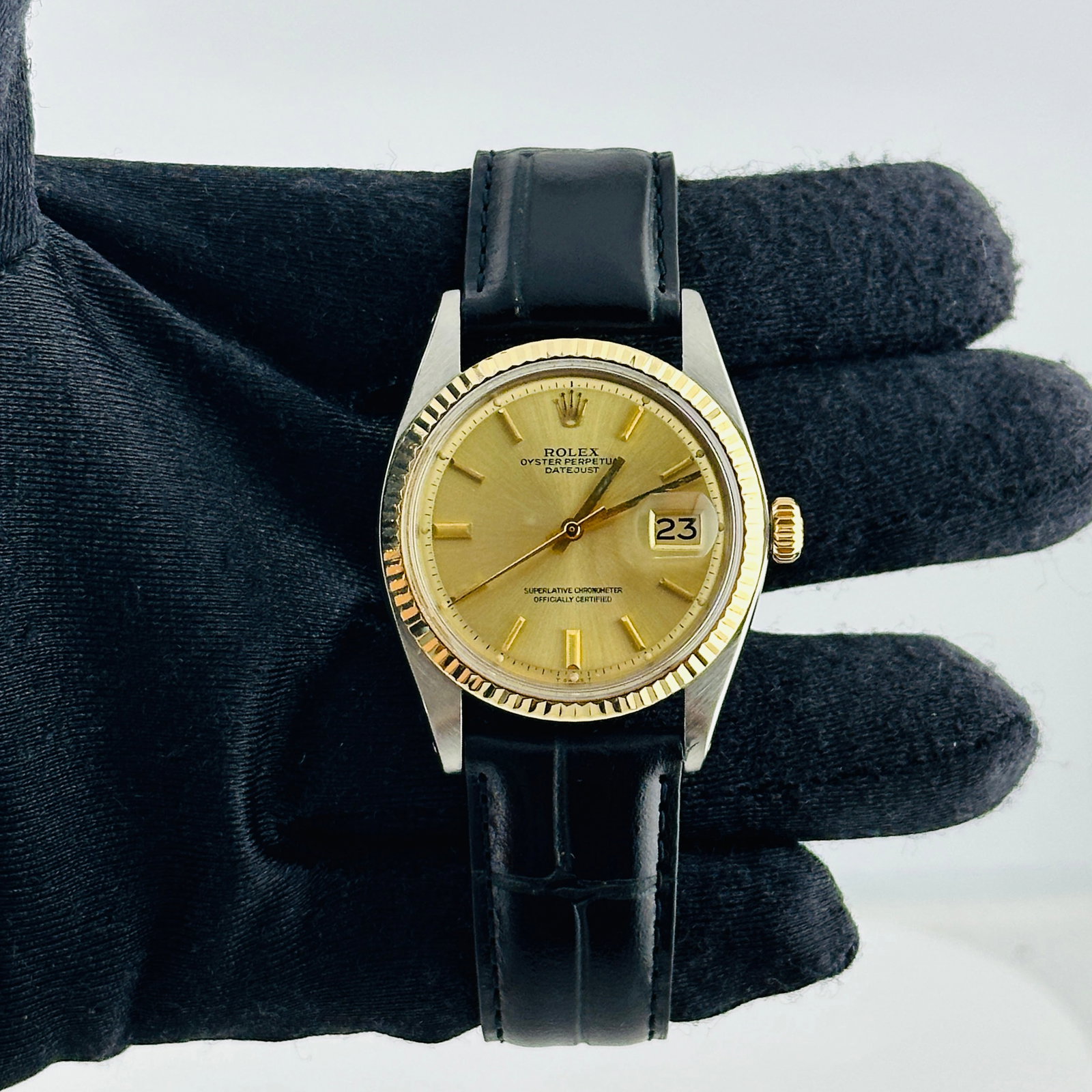 Rolex Datejust 1601 Champagne Stick Dial Leather Band: Rolex Datejust 1601 Champagne Stick Dial Leather Band This Rolex Datejust watch features a champagne stick dial and a fluted bezel, paired with a generic leather band. The timepiece is identified by r