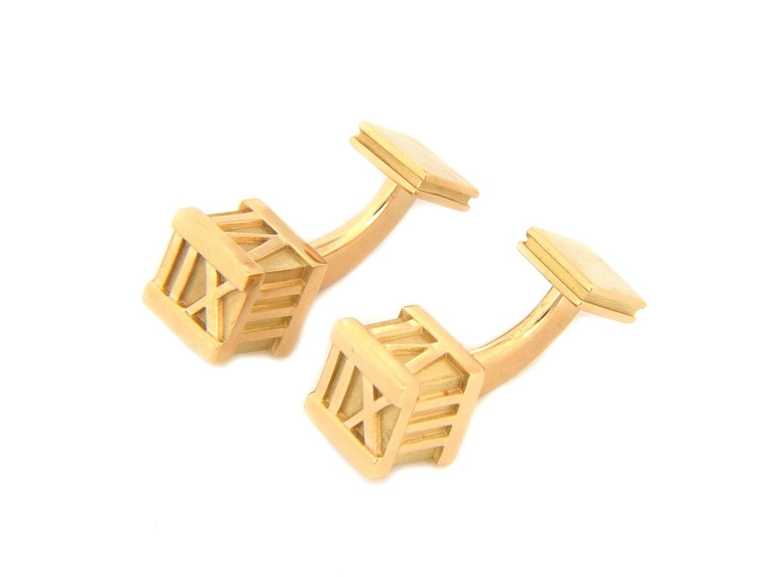 Tiffany & Co. Atlas 18k Yellow Gold Roman Numeral Cufflinks: Tiffany & Co. Atlas 18k Yellow Gold Roman Numeral Cufflinks Elevate your style with this striking pair of cufflinks from Tiffany & Co.'s Atlas Collection. Expertly crafted from luxurious 18k yellow go