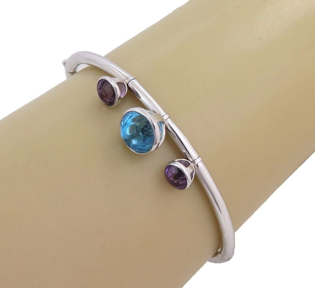 Gerrard 18k White Gold Charm Bangle Bracelet Blue Topaz Amethyst: Gerrard 18k White Gold Charm Bangle Bracelet Blue Topaz Amethyst This Gerrard charm bangle bracelet is crafted from 18k white gold and features a sleek, modern silhouette. The bracelet is adorned with