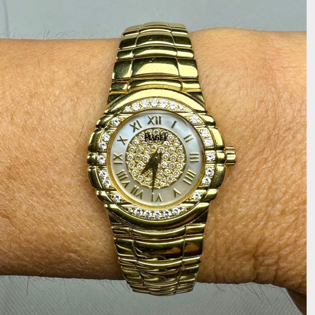 Piaget 18K Yellow Gold Ladies Watch Diamond Bezel Mother-of-Pearl Dial: Piaget 18K Yellow Gold Ladies Watch Diamond Bezel Mother-of-Pearl Dial This exquisite Piaget ladies watch is crafted from 18K yellow gold, exuding elegance and sophistication. Weighing 82.6 grams, it 