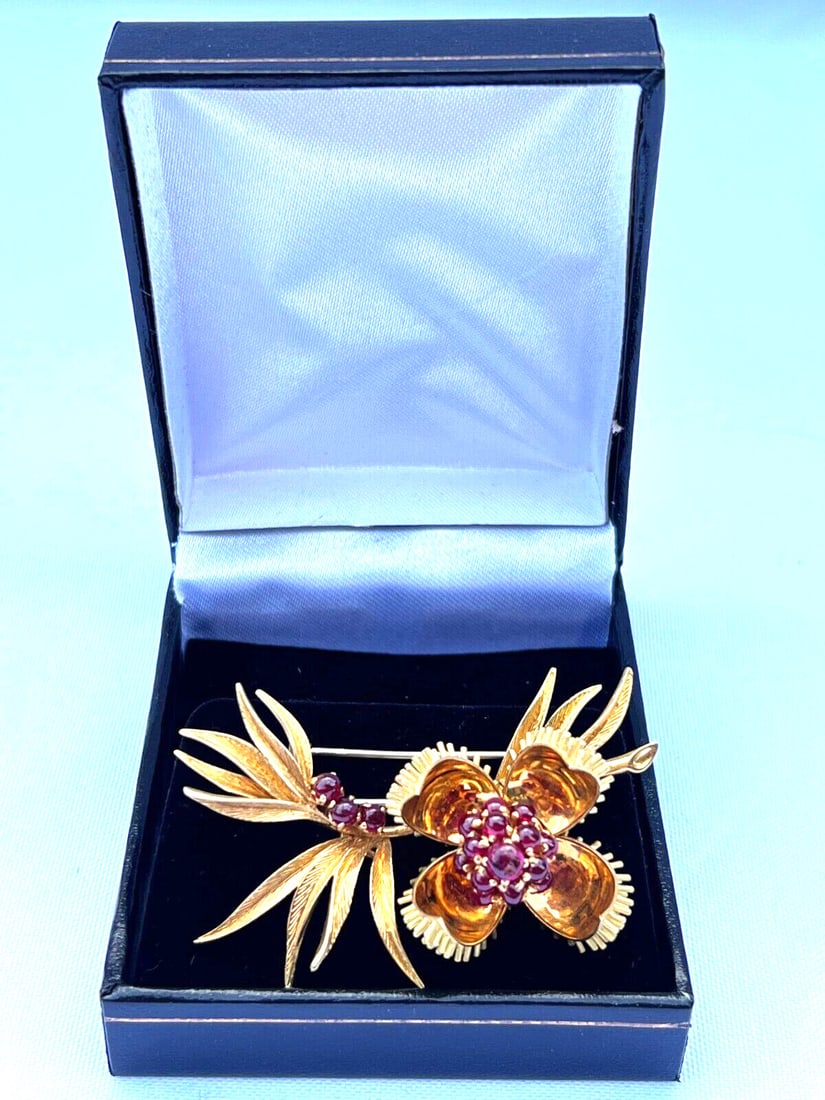 French 18K Yellow Gold Ruby Flower Brooch Signed Made in France: French 18K Yellow Gold Ruby Flower Brooch Signed Made in France This exquisite French brooch showcases a stunning flower design crafted from 18K yellow gold. The brooch features a vibrant ruby as its 