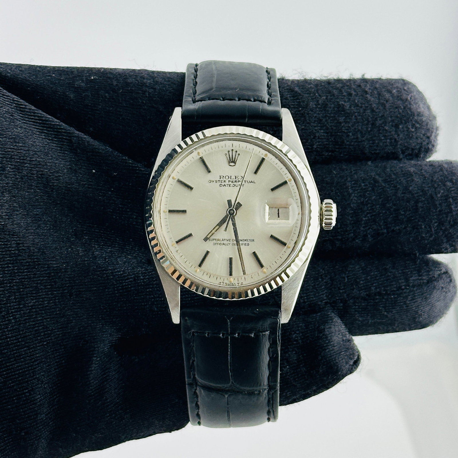 Rolex Datejust 1601 Silver Stick Dial Leather Band: Rolex Datejust 1601 Silver Stick Dial Leather Band This Rolex Datejust watch features a silver stick dial and a fluted bezel, paired with a generic leather band. The timepiece is identified by referen