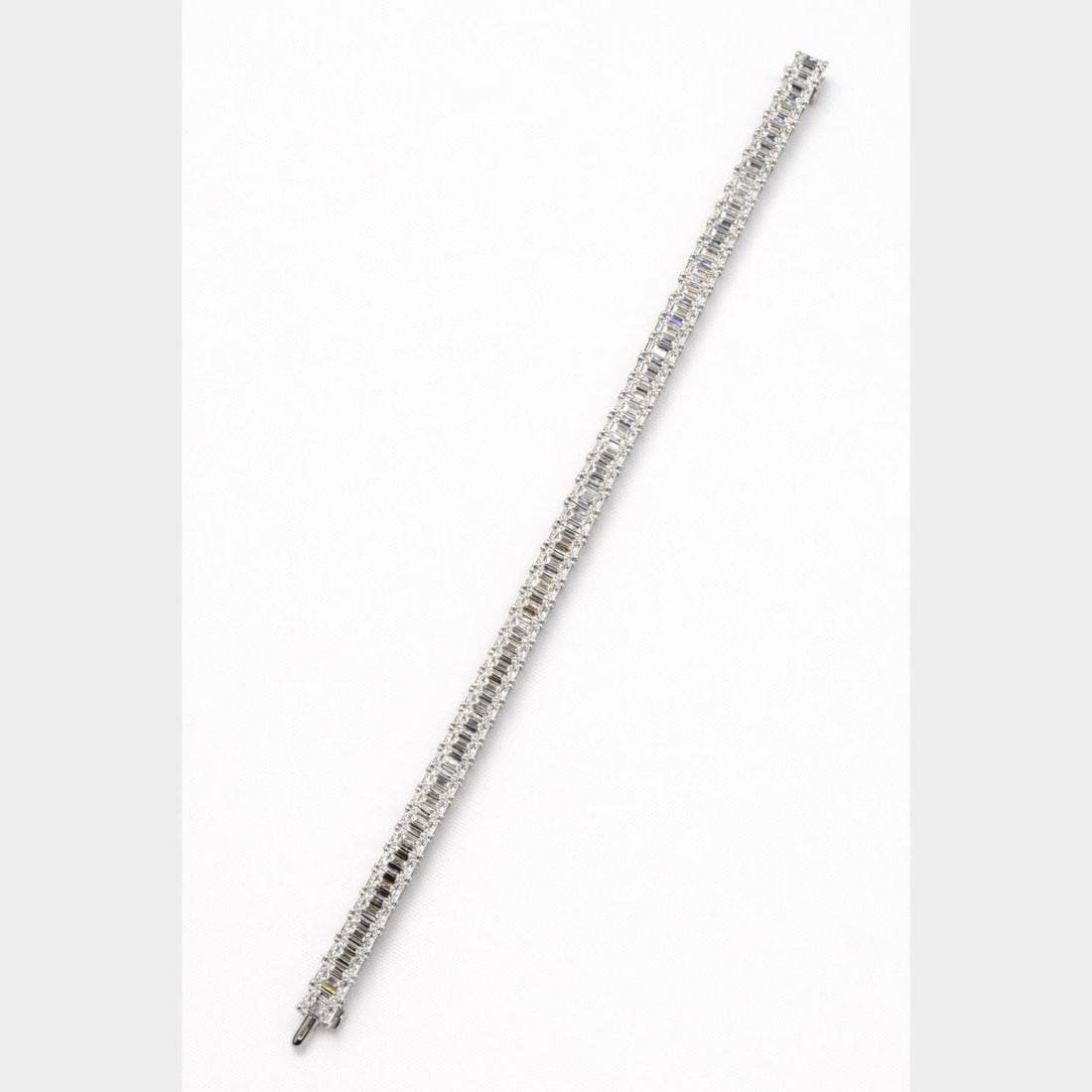 Emerald Cut Diamond Tennis Bracelet in Platinum 19.86 Carats 7 Inch: Emerald Cut Diamond Tennis Bracelet in Platinum 19.86 Carats 7 Inch This platinum tennis bracelet features 49 emerald-cut diamonds with a total stamped weight of 19.86 carats. The diamonds are graded 