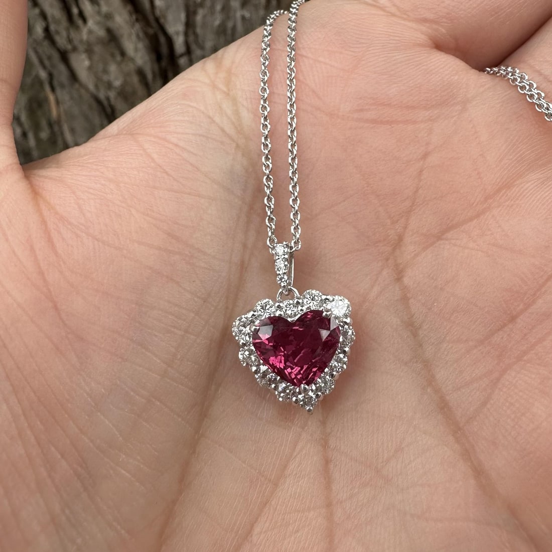 Platinum GIA Certified 2.61ctw Red Heart Ruby Diamond Halo Necklace: Platinum GIA Certified 2.61ctw Red Heart Ruby Diamond Halo Necklace This stunning pendant necklace features a captivating natural heart-shaped ruby, weighing 1.99ct, surrounded by a diamond halo. The 