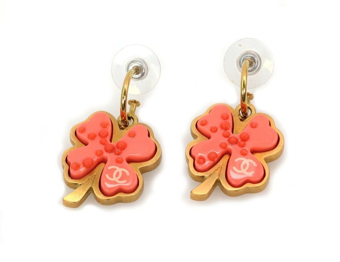 Chanel four leaf clover dangle earrings orange resin yellow gold tone metal: Chanel four leaf clover dangle earrings orange resin yellow gold tone metal These Chanel Four Leaf Clover dangle earrings are crafted from yellow gold plated metal and feature sculptural orange resin 