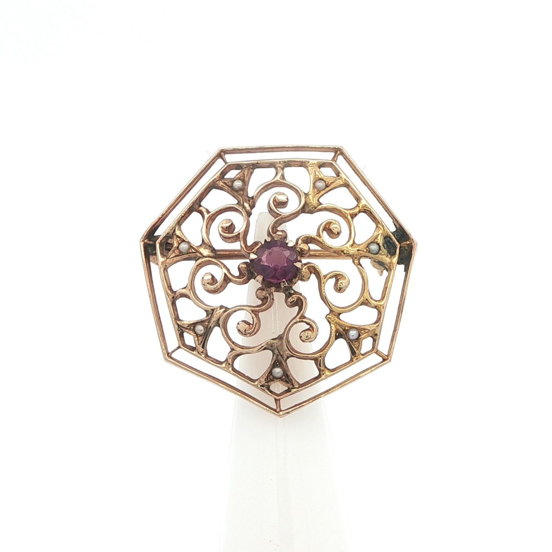 10k Yellow Gold Antique Brooch with Amethyst and Seed Pearls Openwork Design: 10k Yellow Gold Antique Brooch with Amethyst and Seed Pearls Openwork Design This antique pin brooch features an open work design crafted in solid 10k yellow gold. It is adorned with a round, natural 