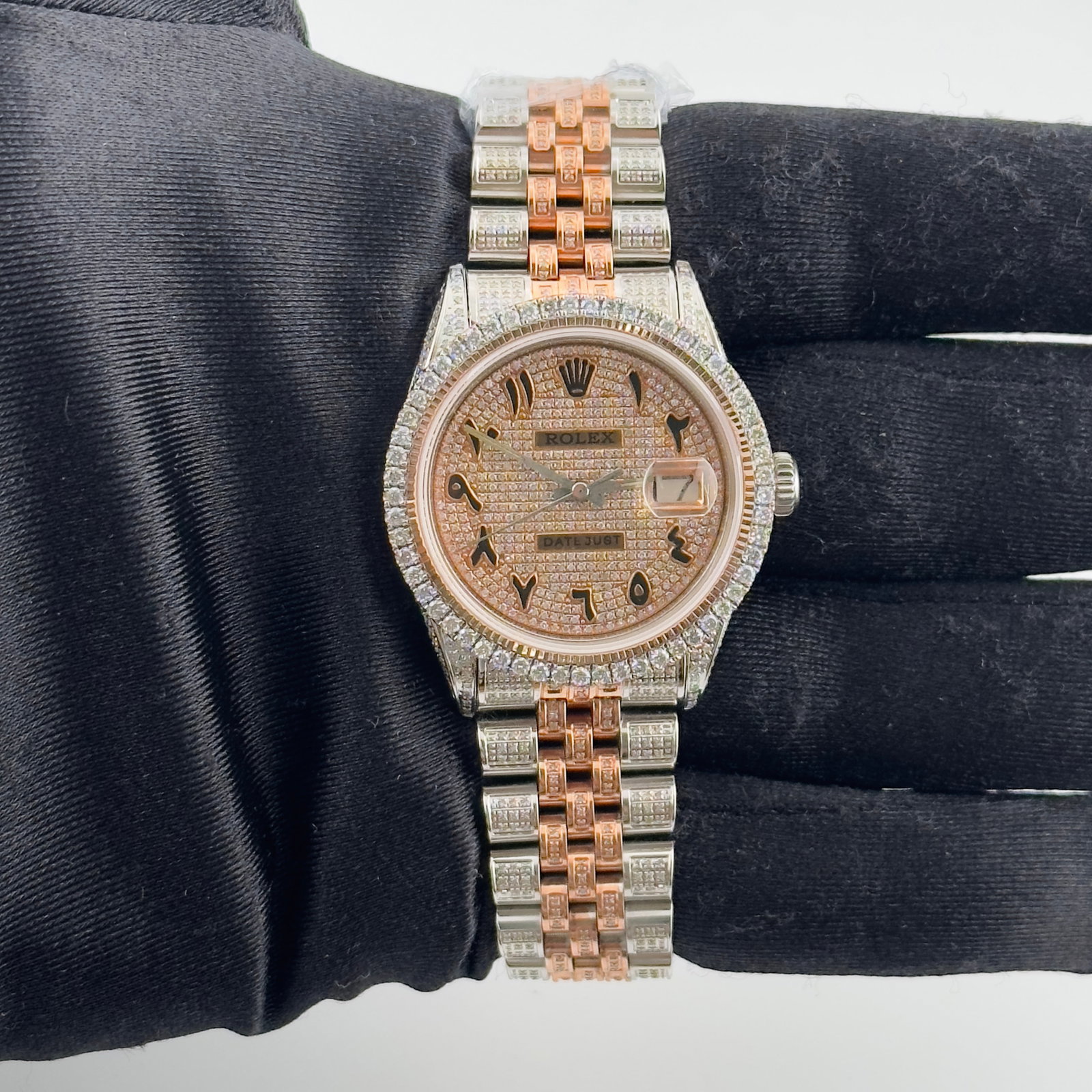 Datejust Ref 1601 Watch with Rose Gold Arabic Dial and Jubilee Bracelet: Datejust Ref 1601 Watch with Rose Gold Arabic Dial and Jubilee Bracelet This Rolex Datejust men's watch features a rose gold dial with Arabic numerals, paired with a Jubilee bracelet. The prong plated