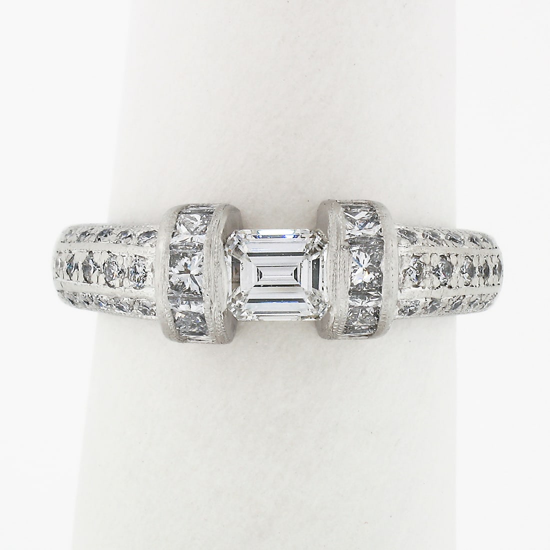 Vintage Platinum 1.35ct Floating Diamond Engagement Ring with Accents: Vintage Platinum 1.35ct Floating Diamond Engagement Ring with Accents This exquisite vintage band ring is masterfully crafted from solid .900 platinum, showcasing a stunning floating emerald cut diamo