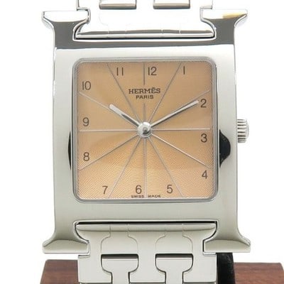 Hermes HH1.510 stainless steel quartz wristwatch: Hermes HH1.510 stainless steel quartz wristwatch This pre-owned HERMES H Watch HH1.510 is a classic men's wristwatch featuring a distinctive pink dial and a silver stainless steel case. The bold "H" m