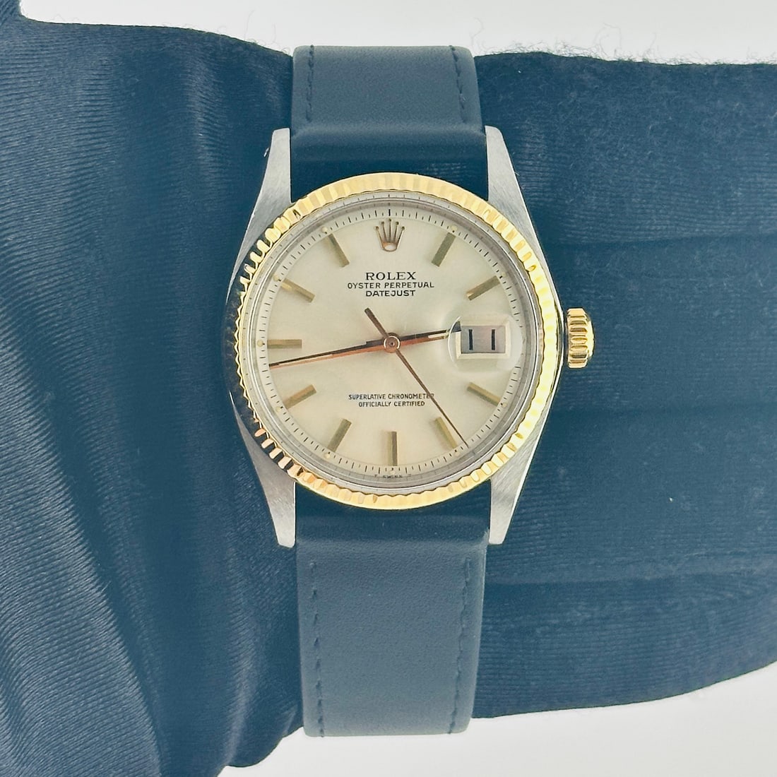 Rolex Datejust 1601 Ivory Gold Stick Dial Leather Band: Rolex Datejust 1601 Ivory Gold Stick Dial Leather Band This Rolex Datejust features an ivory dial with gold stick markers, complemented by a fluted bezel. The watch is paired with a generic leather ba