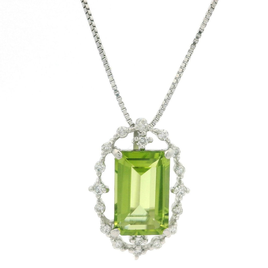 18k White Gold 3.24ctw Emerald Peridot Diamond Halo Pendant Necklace: 18k White Gold 3.24ctw Emerald Peridot Diamond Halo Pendant Necklace This elegant necklace features a stunning long emerald-cut peridot, weighing 3.04 carats, beautifully prong set in solid 18k white 