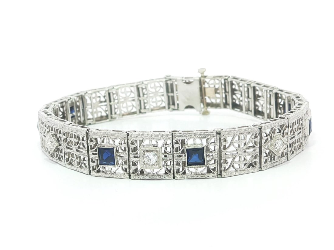 Art Deco Filigree Bracelet with Diamonds and Blue Sapphires in Gold and Platinum: Art Deco Filigree Bracelet with Diamonds and Blue Sapphires in Gold and Platinum This antique Art Deco bracelet features intricate filigree openwork crafted from solid 18k white gold with a platinum t