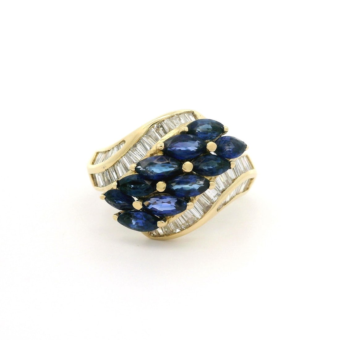 18k Yellow Gold 3.02ct Marquise Sapphire Baguette Diamond Ring: 18k Yellow Gold 3.02ct Marquise Sapphire Baguette Diamond Ring This exquisite bypass style ring features a stunning combination of natural sapphires and diamonds, set in solid 18k yellow gold. The rin