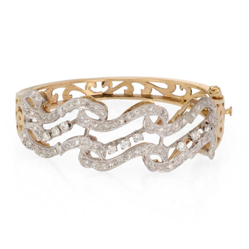 Estate 2.4ct Diamond 14k Two Tone Gold Scroll Bracelet: Estate 2.4ct Diamond 14k Two Tone Gold Scroll Bracelet This stunning estate bracelet is a beautiful combination of 14k yellow and white gold, featuring an intricate scroll design. The hinged band is c