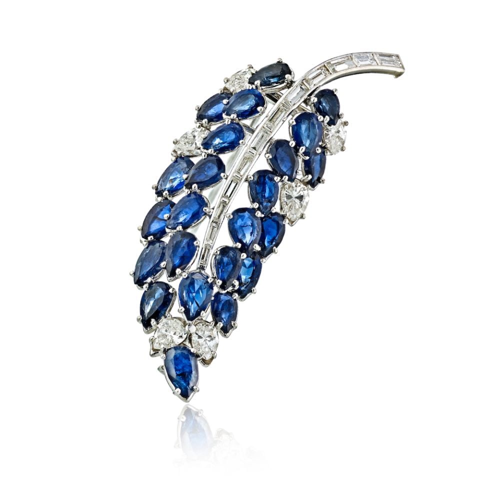 Platinum Brooch with 23 Sapphire and Diamond Leaf Design: Platinum Brooch with 23 Sapphire and Diamond Leaf Design This exquisite Platinum Sapphire and Diamond Leaf Brooch features a stunning arrangement of 23 pear cut sapphires complemented by sparkling whi