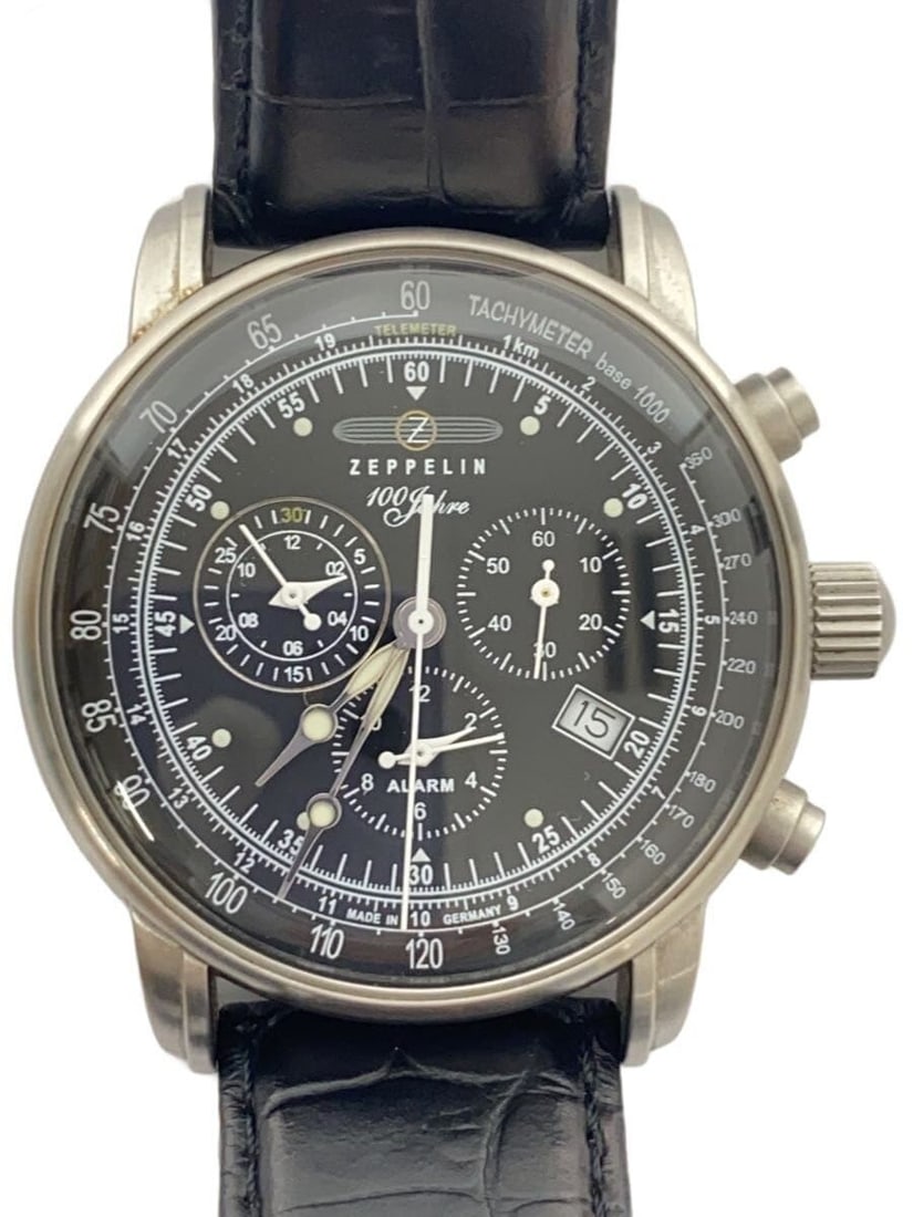 Zeppelin 7680 Black Leather Men's Quartz Wristwatch: Zeppelin 7680 Black Leather Men's Quartz Wristwatch This Zeppelin 100th Anniversary Quartz 7680 men's wristwatch features a black dial and a leather strap. Made in Germany, this pre-owned watch displa