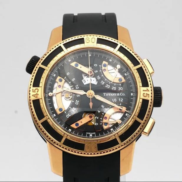 Tiffany Co Tri-Retrograde T-57 Men's Leather Band Black Rose Dial: Tiffany Co Tri-Retrograde T-57 Men's Leather Band Black Rose Dial This Tiffany & Co. Tri-Retrograde wristwatch features a striking black and rose dial, complemented by a rotating bezel operated via th