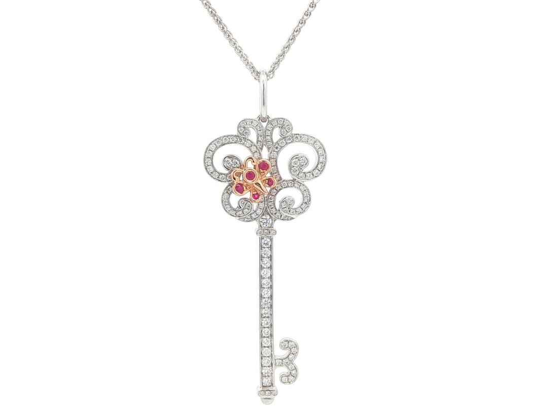 Floral Key Pendant Necklace in 18k White Gold with Diamonds and Rubies Wheat Chain: Floral Key Pendant Necklace in 18k White Gold with Diamonds and Rubies Wheat Chain This women's necklace features a large, intricately detailed floral key pendant crafted in solid 18k white gold. The 