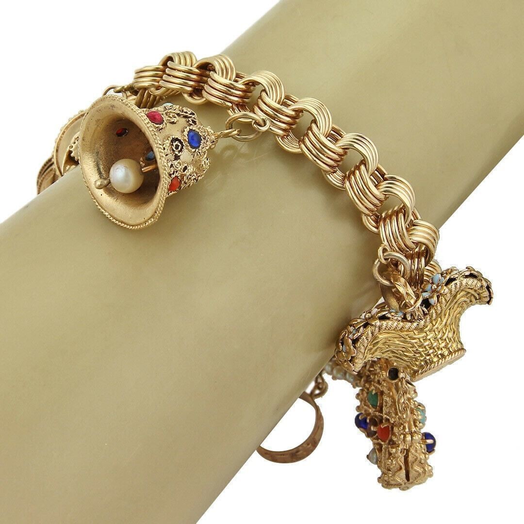 14k Yellow Gold Charm Bracelet with 9 Gemstone Charms: 14k Yellow Gold Charm Bracelet with 9 Gemstone Charms This vintage estate charm bracelet is crafted in solid 14k yellow gold and features a substantial grooved link chain with nine detailed charms. Th