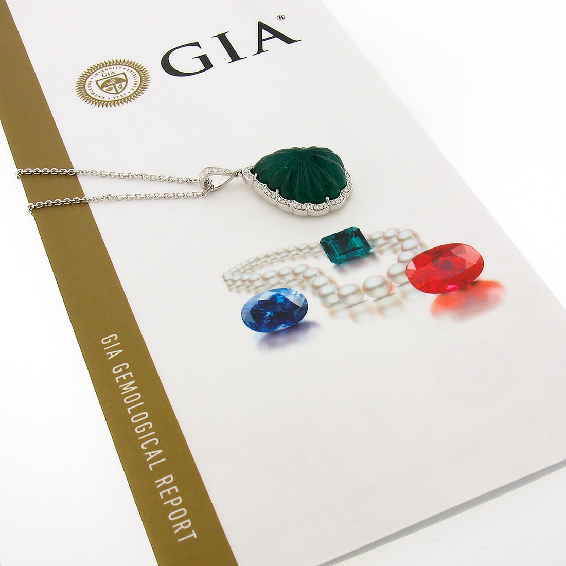 18k White Gold GIA Certified Pear Emerald Diamond Scalloped Pendant & 18" Chain: 18k White Gold GIA Certified Pear Emerald Diamond Scalloped Pendant & 18" Chain This stunning pendant necklace showcases a magnificent 21.49-carat natural emerald in a pear-shaped cabochon cut, beauti